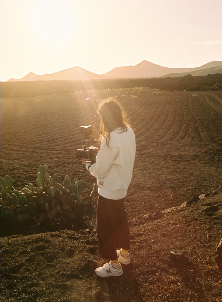 Photo of Giulia at golden hour, filming a field